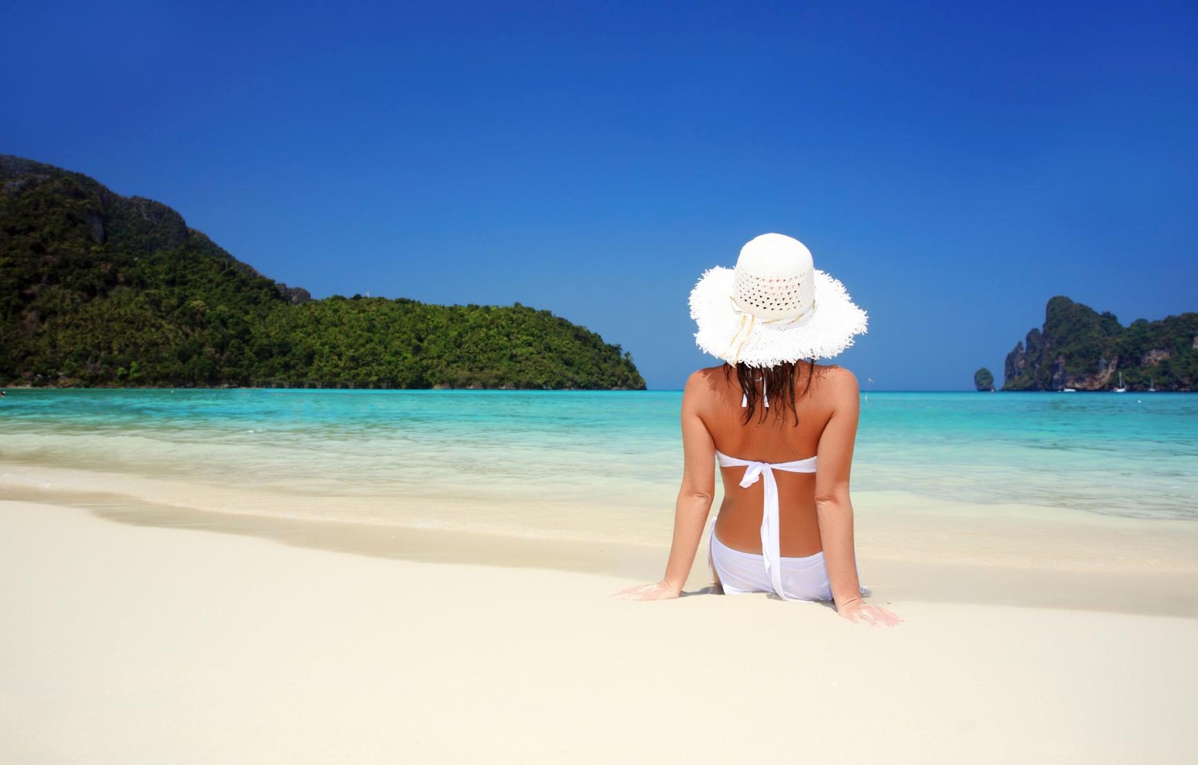 Le chevalet digital vitrine 43'pouce diffuse une image d'une femmes assis sur plage de sable blanc et mer bleu d'une clarté magnifique. 